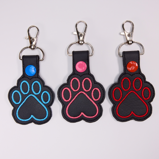 Threadify Shop embroidered paw print keychain in blue pink and red stitching on black leather