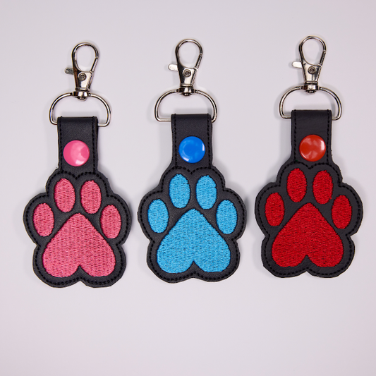 Threadify Shop embroidered paw print keychain set in pink blue and red with black edging and metal clips