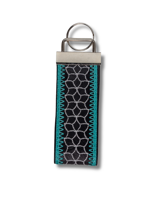 Threadify Shop handmade embroidered keychain with black fabric and blue geometric stitching