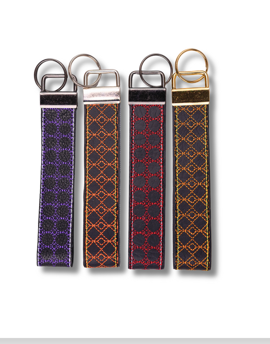 Set of four handmade embroidered wristlet keychain with metal rings in purple red and orange stitching